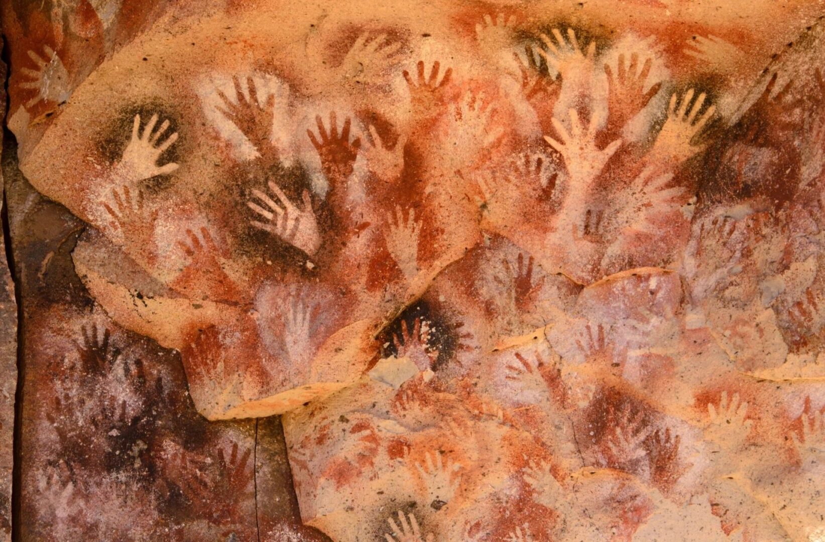 A group of hands are painted on the wall.